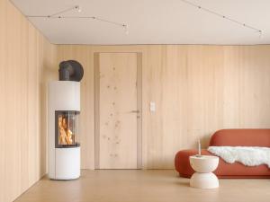 a living room with a fireplace and a red couch at Haus des Onkels in Hittisau