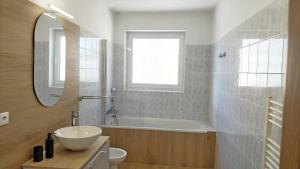 a bathroom with a sink and a tub and a mirror at Apartmany Zlatovska in Trenčín +28 photos