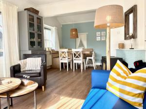 a living room with a couch and a table at Holiday home Zeeroos in Koudekerke