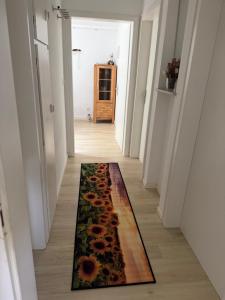 a hallway with a flower rug on the floor at DeNi's Ferienwohnungen in Klotten