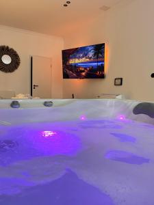 a hot tub with purple lights in a room at Le Rêve de Stanislas - Jacuzzi Nancy centre in Nancy