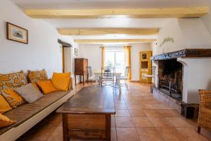a living room with a couch and a fireplace at Bastide de Marius in Redortiers