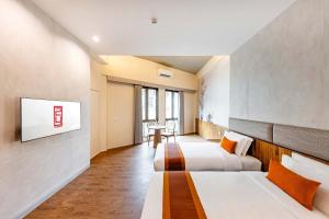 a hotel room with two beds and a tv at Taladnoi 24 Hostel in Bangkok