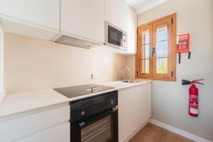 a kitchen with a sink and a stove and a window at CARABELA 93 in Alcudia +12 photos