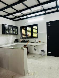 a large kitchen with a sink and a counter at Mausam Homestay in Sultan Bathery