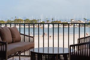 a balcony with a couch and a table and a beach at CARABELA 93 in Alcudia