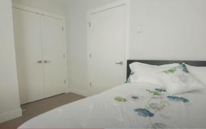 a bedroom with a bed with two white cabinets at Elite Townhouse at the Shipyaards in North Vancouver +11 photos