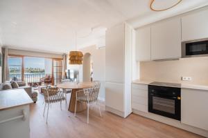 a kitchen and living room with a table and chairs at CARABELA 93 in Alcudia
