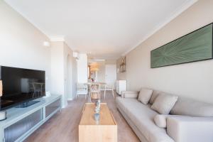 a living room with a couch and a tv at CARABELA 93 in Alcudia