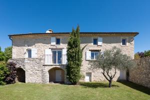 an old stone house with a tree in front of it at Bastide de Marius in Redortiers