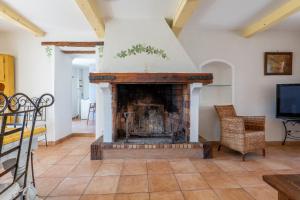 a living room with a fireplace and a tv at Bastide de Marius in Redortiers