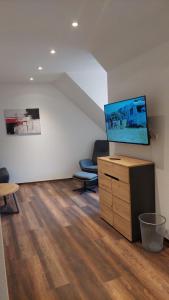 a living room with a flat screen tv on a dresser at Ferienwohnung an der Holtemme in Derenburg