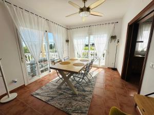 a dining room with a table and chairs and windows at Villa El Dorado in Estepona