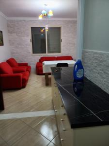 a living room with a red couch and a living room with a table at Flodril Appartment in Durrës
