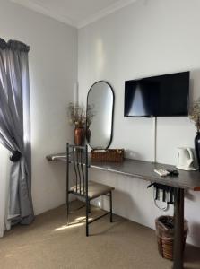 a room with a desk with a mirror and a chair at Anja Guesthouse in Modimolle