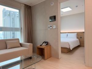 a hotel room with a bed and a couch at TRAVELUS Myeongdong 트래블어스 명동 in Seoul