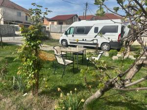 a table and chairs in a yard with a white van at Camping Struga Macedonia in Struga