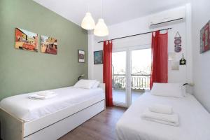 two beds in a room with a window at The Garden Villa Hanioti in Hanioti