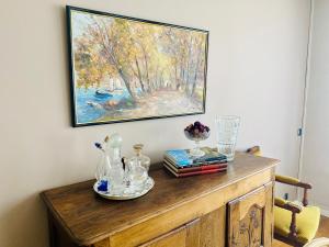 a painting hanging on a wall above a wooden cabinet at L'escale vosgienne in Saint Die