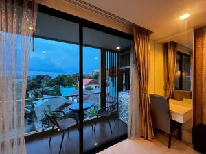 a room with a balcony with a view of the ocean at The Pixel Sri Panwa, Phuket in Ban Ao Makham