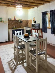 a kitchen with a table and chairs in a kitchen at By Lela in Tinogasta