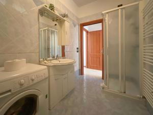 a bathroom with a washing machine and a sink at Welc-ōM Conselve Matteotti in Conselve +12 photos