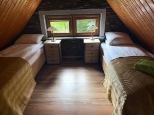 two beds in a room with a window at Agroturystyka Monte Luna domki in Czarnów