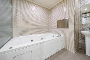 a white bathroom with a tub and a sink at 자자호텔 in Goseong