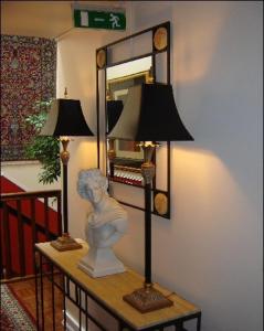 une statue sur une table avec une lampe et un miroir dans l'établissement Hotel Phoenix, à Reykjavik