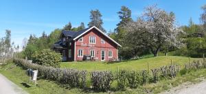 a red and black house on a green field at B&B Idala in Mellerud