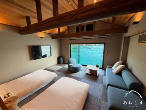 a large room with two beds and a couch at Aoshima あおしま in Kameshima