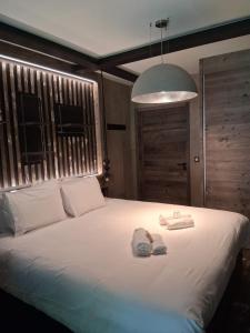 a bedroom with a white bed with two towels on it at Le Tresor du Chateau in Menthon-Saint-Bernard