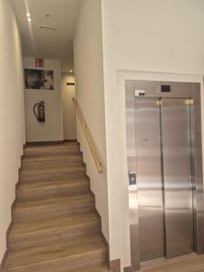 a staircase with a glass elevator in a building at Hotel General Ricardos in Madrid