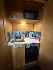 a small kitchen with a sink and a microwave at Little Fairfield in Ashover