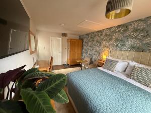 a bedroom with a bed with a blue comforter at Little Fairfield in Ashover