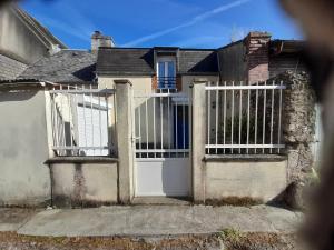a white gate of a house with a house at Studio in Isigny-sur-Mer