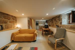 a bedroom with a bed and a chair in a room at Casa Ti Nogueira in Soajo
