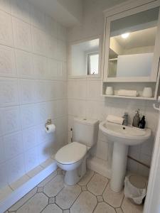 a white bathroom with a toilet and a sink at The Rock House in Cobh +13 photos