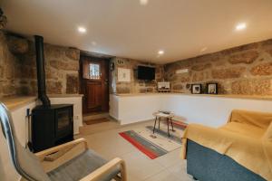 a living room with a fireplace and a tv at Casa Ti Nogueira in Soajo