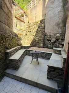 a patio with a table and a stone wall at The Rock House in Cobh