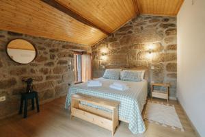 a bedroom with a bed and a stone wall at Casa Ti Nogueira in Soajo