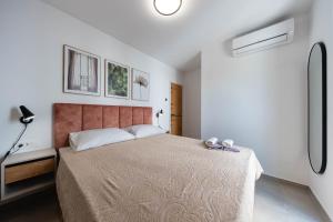 a bedroom with a large bed and a lamp at Premium Šimuni by Pag tours in Šimuni