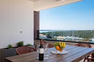 a wooden table with a bottle of wine and bananas on it at Premium Šimuni by Pag tours in Šimuni