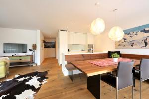a kitchen and dining room with a cow rug at Fontana in Arosa