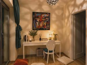 a desk with a chair and a painting on the wall at Artystyczny Picasso apartament z widokiem na jezioro i tarasem in Charzykowy