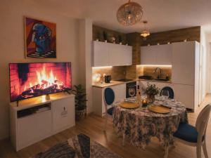 a kitchen with a table and a fireplace in a room at Artystyczny Picasso apartament z widokiem na jezioro i tarasem in Charzykowy