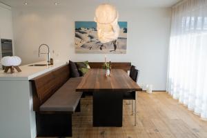 a dining room with a table and a kitchen at Fontana in Arosa +6 photos