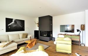 a living room with a couch and a tv at Fontana in Arosa