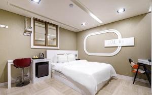 a bedroom with a white bed and a mirror at 자자호텔 in Goseong