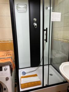 a shower with a glass door next to a sink at Cozy 2 BR Apartment with Easy Access in Ulaanbaatar +21 photos